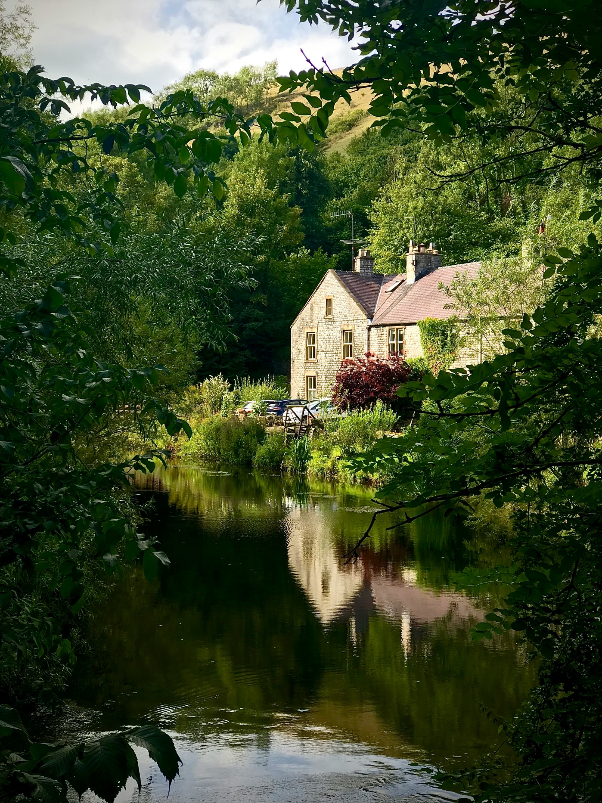 Stone cottage reflected in the river